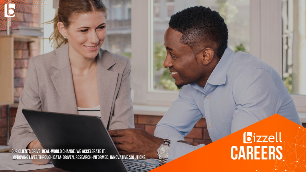 two people sitting in front of a laptop