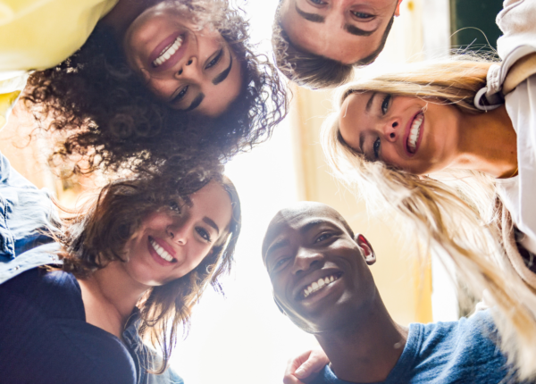 group of people in a circle looking down at the camera